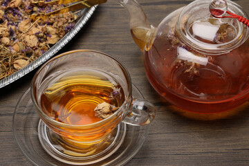 Make mix pour herbal floral tea drink transparent glass teapot to teacup twister pick up put rustic wooden table