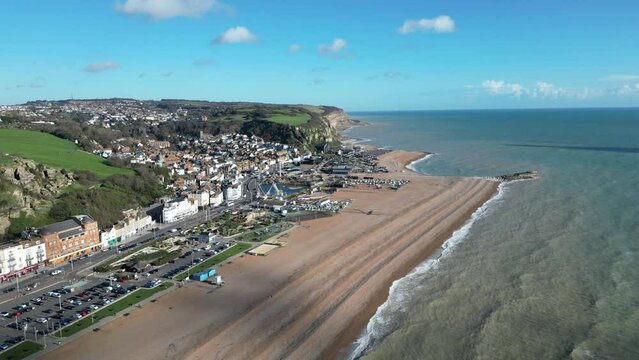 Aerial drone shot of Hastings UK, Wide Tracking shot of the Land Based Fishing Fleet of Beach, Old Town and East Hill Cliff and coast line. ENGLAND UK 4K DRONE AERIALS