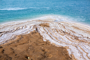 View of Dead Sea coastline at sunset time in Jordan. Salt crystals at sunset. Dead sea landscape with mineral structures.