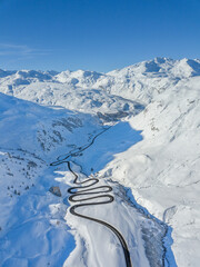 Aerial view of the winding road over the  Julier Pass in Swiss Alps mountain in winter full of snow, Canton Grison, Switzerland