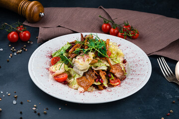 Salad with bacon, lettuce, cherry tomatoes, onion, pomegranate seeds and pepper.