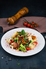 Georgian salad with bacon, lettuce, cherry tomatoes, onion, pomegranate seeds and pepper.