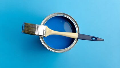 can of blue paint with brush on blue background top view