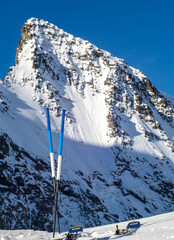 Ski de randonnée et bâtons élégants devant un sommet enneigé