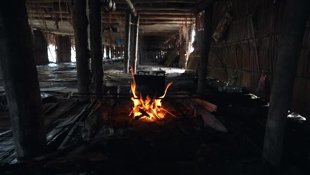 Inside unmarried Indonesian men Bachelor's house, pot on fire inside hut