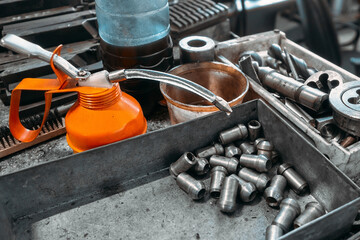 Metal turning shop. Metal fittings are in tray. Turning metal parts on lathe. Professional...