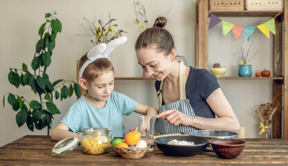 Happy Easter with your family. Mom and son are preparing for spring Easter by cheerfully coloring holiday eggs