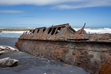  S.S. Waitangi shipwreck. Rusty shipwreck at Mana Bay New Zealand. Patea. Taranaki. Tasman Sea. Coast and Beach. Lava sand.