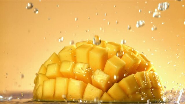 Raindrops fall on fresh mango. Filmed on a high-speed camera at 1000 fps. High quality FullHD footage