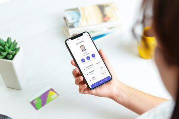 Woman adds credit card and account on a fintech service app, displayed on a modern smartphone. Featuring the account and a transaction list for seamless financial management