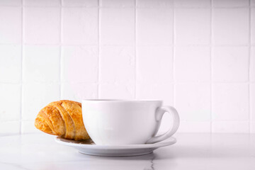 Black espresso coffee cup with croissant and coffee beans, simple traditional french breakfast 