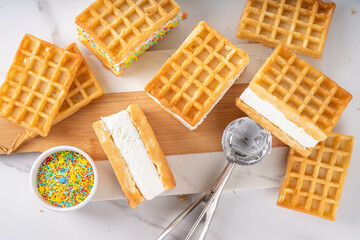 Waffle ice cream sandwiches. Tasty ice cream with fluffy belgian waffles and sugar sprinkles,...