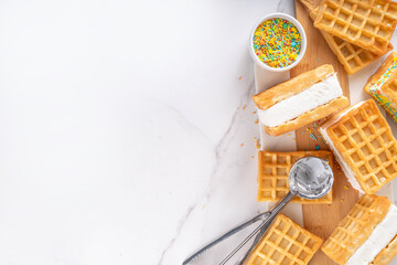 Waffle ice cream sandwiches. Tasty ice cream with fluffy belgian waffles and sugar sprinkles,...