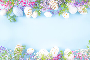 Happy Easter greeting card background with easter eggs and spring flowers. Easter holiday flat lay composition with copy space for text