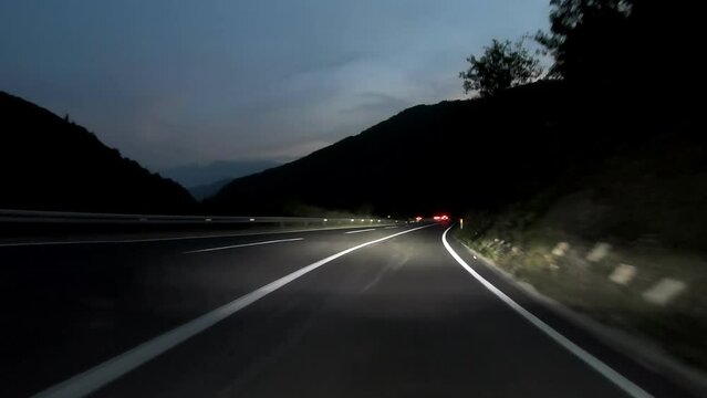 driving a car on countryside road at night with adaptive matrix headlights