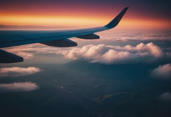 Fototapeta premium The view from the airplane window to the clouds and sunset. Airplane wing above thick pink and orange clouds. Wonderful breathtaking view.