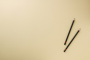Pencil with black paint and a red stripe on a yellow background