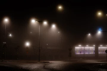 Fototapeten Stockholm, Sweden A foggy scene at night of a street and intersection in the Liljeholmen suburb. © Alexander