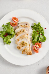 Grilled chicken breast with vibrant salad garnish on a minimalistic white setup, perfect for clean eating and diet concepts
