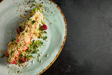 Artfully plated salad with avocado, crab, and quinoa, served on a speckled turquoise plate, viewed from above