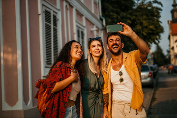 Trio of friends reveling in city life, snapping memories with a phone in hand