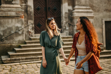 Young women holding hands and discovering new places and enjoying the urban vibe