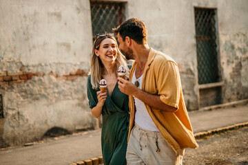 Happy couple enjoying a sweet treat together on a sunny summer day.