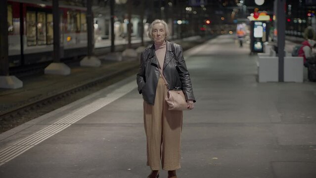 Worried Elderly Woman Waiting at Crowded Trainstation Traveling
