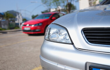 Obraz na płótnie Canvas Closeup of clean headlights of silvery car in parking. Cars sale concept