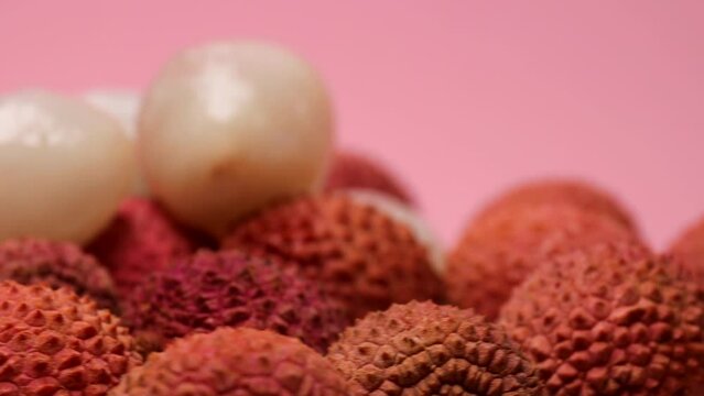 Lychee fruits macro, rotation in circle. tropical fruit lychee, Turning. selective focus. Lychee fruits on a pink background	