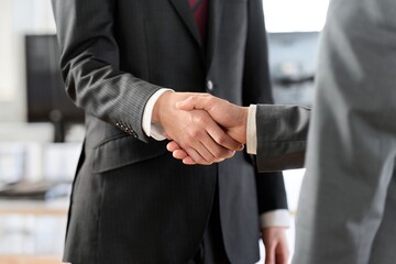 オフィスで握手をするアジア人ビジネスマン