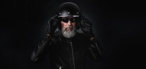 Portrait d'un motard homme avec un casque et une veste en cuir et des lunettes de protection et une...