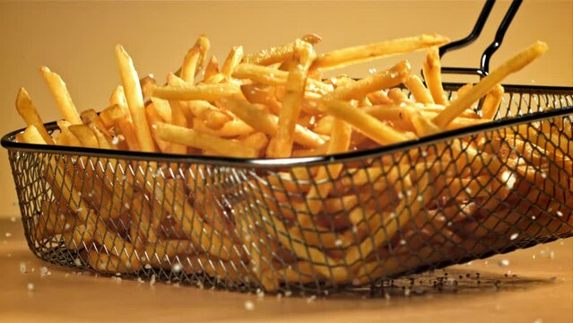 French fries with salt fall on the table. Filmed on a high-speed camera at 1000 fps. High quality FullHD footage