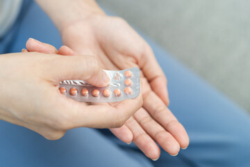 young female holding birth control pills