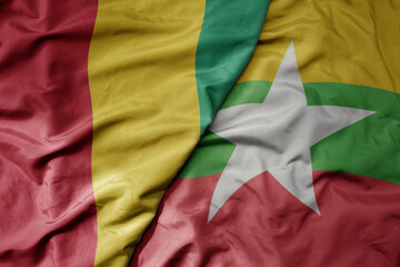 big waving national colorful flag of myanmar and national flag of guinea .