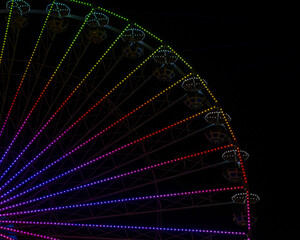 Obraz premium ferris wheel with colored lights in an amusement park at night on a black background