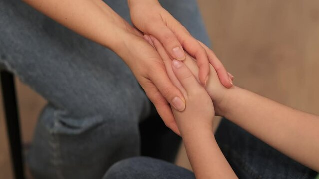 A psychologist or mother extends a soothing touch to a young boy, a cornerstone of emotional support during his formative years.