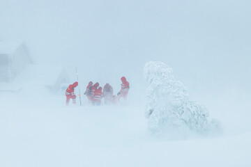 Paramedic team of emergency service helping in mountains in winter during blizzard. Selective focus...