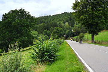 Fototapeta na wymiar Group of Motorcyclists take a tour through the hilly landscape of the Belgian Ardennes