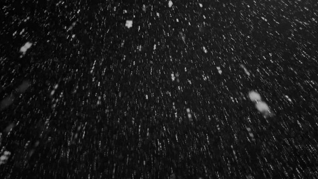 snowfall in the mountains wild nature on a dark winter night by the light of a lantern. Snowflakes spin like little stars, fly like a whirlwind, making your head spin.