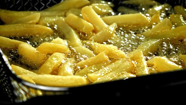 French fries are deep-fried in oil. Filmed on a high-speed camera at 1000 fps. High quality FullHD footage