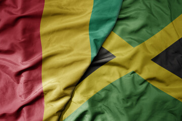 big waving national colorful flag of and national flag of guinea .