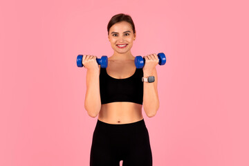 Smiling sporty woman doing fitness routine, training with blue dumbbells