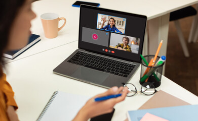 Tutor with laptop having video conference chat with students