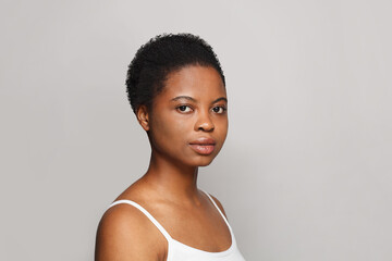Nice African American female model with healthy fresh clear dark skin posing on white background....