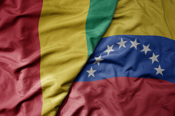 big waving national colorful flag of venezuela and national flag of guinea .