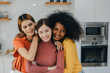 Multiethnic lesbian couple having embracing in kitchen room. black and white couple holding ring....