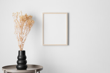 Wooden frame mockup on the wall with a gypsophila decoration.