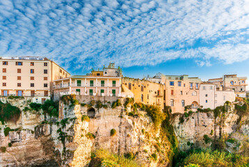 Fototapeta na wymiar scenic travel landscape of beautiful historic town Tropea in Italy with old antique buildings, vintage houses on a high rock cliff above sea and amazing blue sky on background