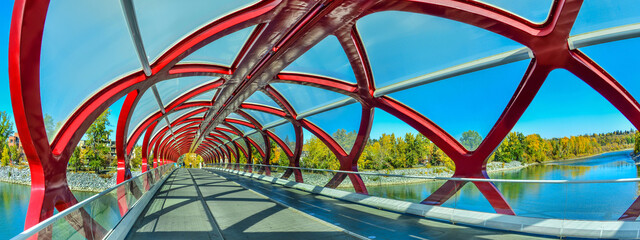 Peace Bridge with Bow River and part of the Calgary downtown in a sunny autumn day.
